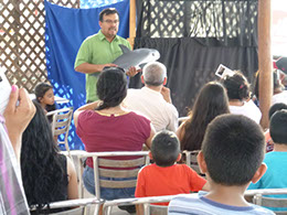 A man gives a talk while holding a model of a vaquita during International Save the Vaquita Day 2015